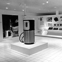 Vintage gas pump on display in a museum setting with educational posters and exhibits.