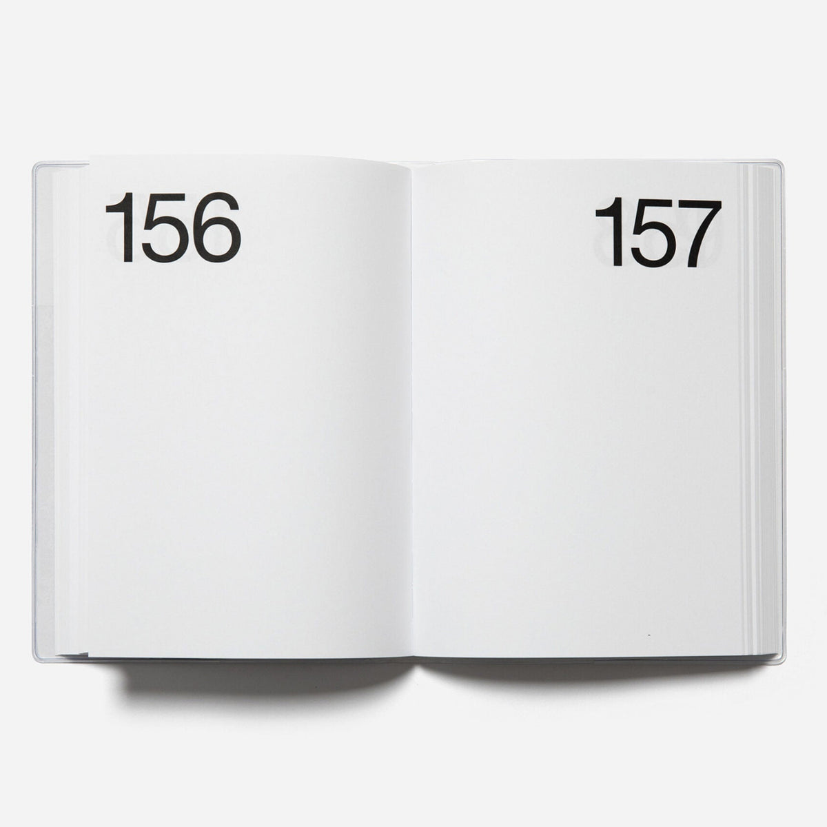 Open planner showing pages numbered 156 and 157 on a white background