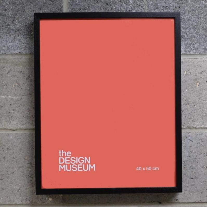 Black picture frame with red poster on a brick wall