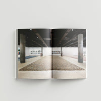 Inside page of Ai Weiwei catalogue with a photograph of a gallery space with concrete pillars.