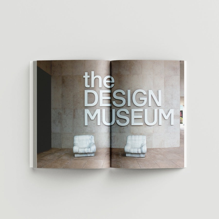 Inside page of Ai Weiwei catalogue with  a photograph of marble sofa chairs against a concrete wall with white bold text reading 'the DESIGN MUSEUM'