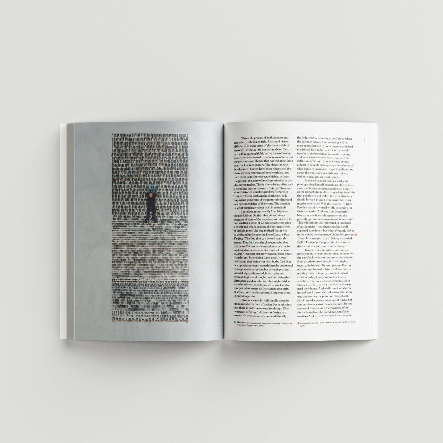 Inside page of Ai Weiwei catalogue with a photograph of a man lying on stones against a light gray background