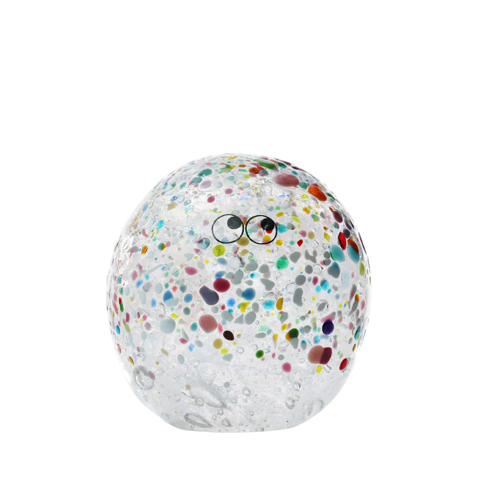 Transparent Arhoj crystal blob with colouful speckles and eyes on a white background.