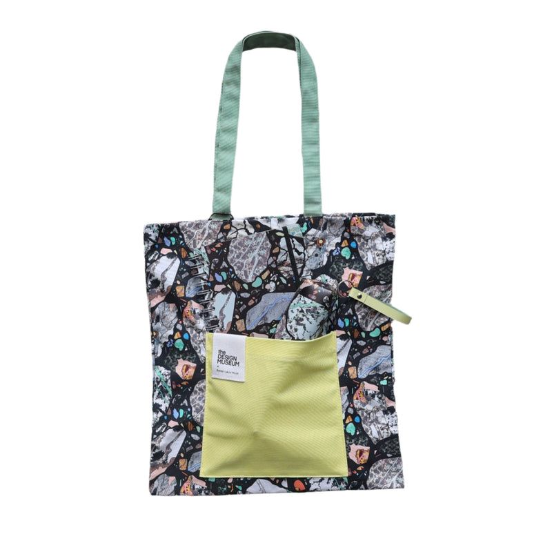 Tote bag with an abstract marbled pattern, with a yellow pouch and green handle on a white background