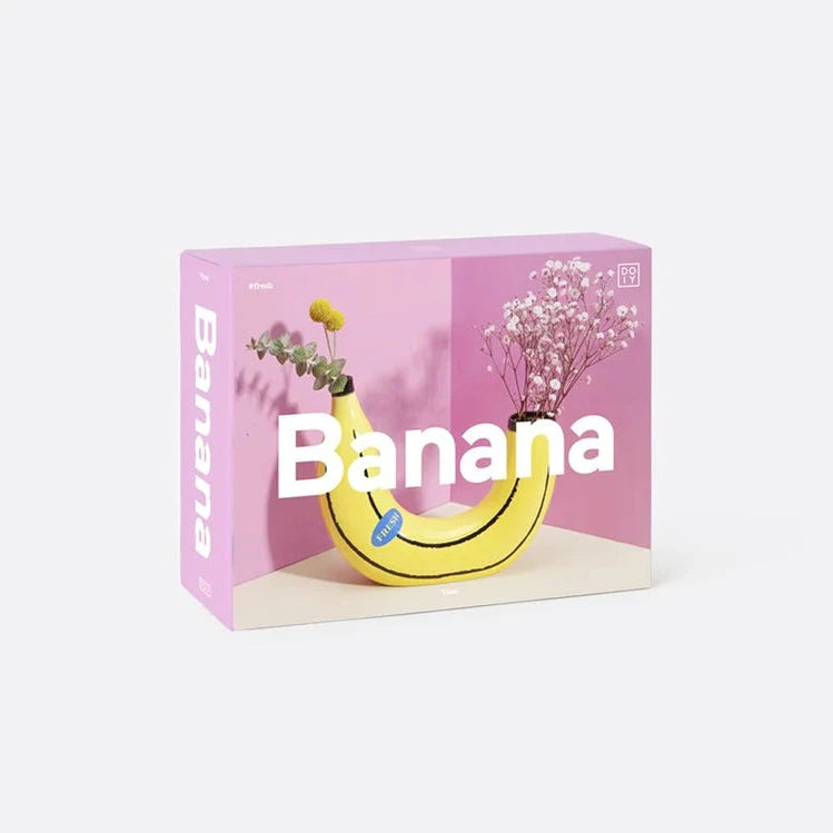 The box for a banana shaped vase featuring a photo of the vase against a pink background.