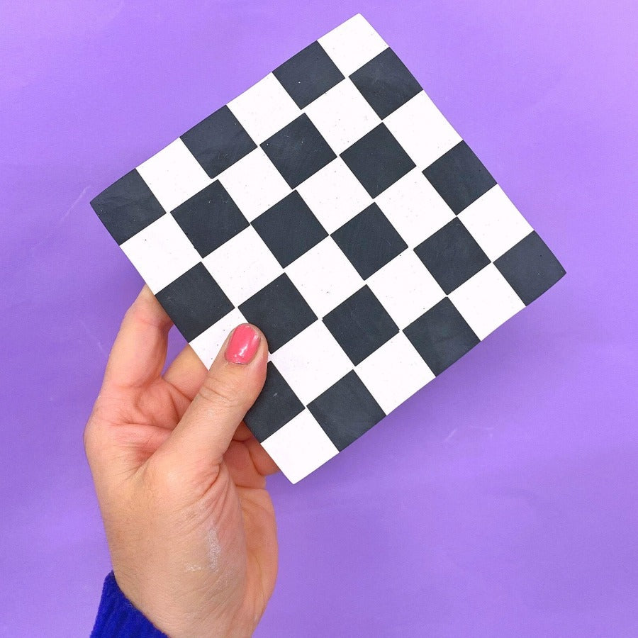 black checkered coaster in hand