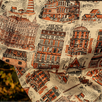 Fabric with printed design of buildings and 'The French Dispatch' text