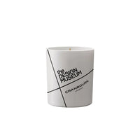 A white cylindrical candle jar with a minimalist black geometric design and text reading 'the DESIGN MUSEUM' and 'CRANBOURN LONDON', centered on a light gray background.