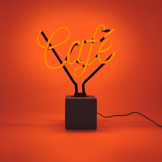 Neon lamp with 'Café' on a black base against an orange background