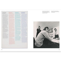 Book page with text on the left and a black and white photo of people at a table on the right.
