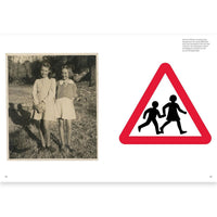Two children standing outdoors next to a road sign with children icon.