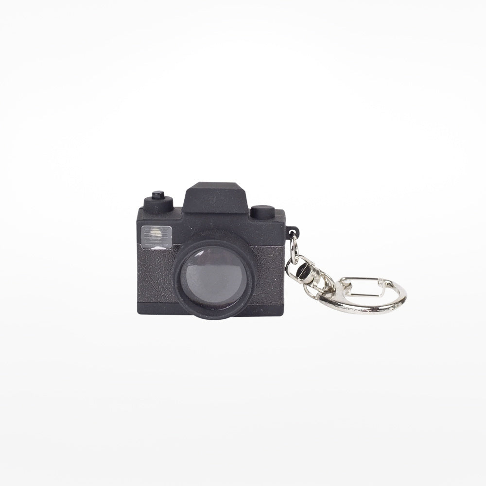 A black camera-shaped LED keychain with a realistic design, including a lens and flash, on a white background.