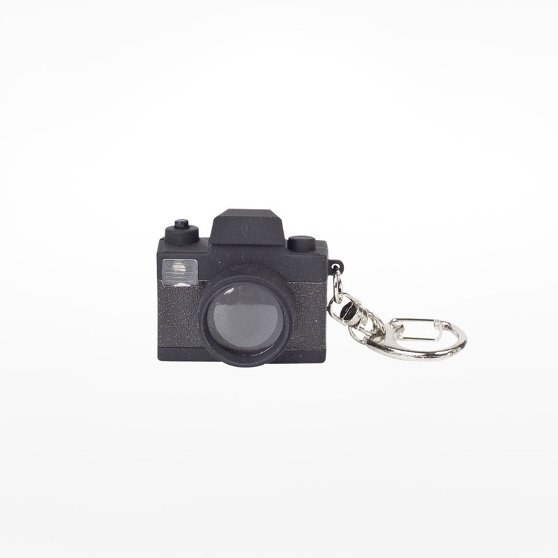 A black camera-shaped LED keychain with a realistic design, including a lens and flash, on a white background.