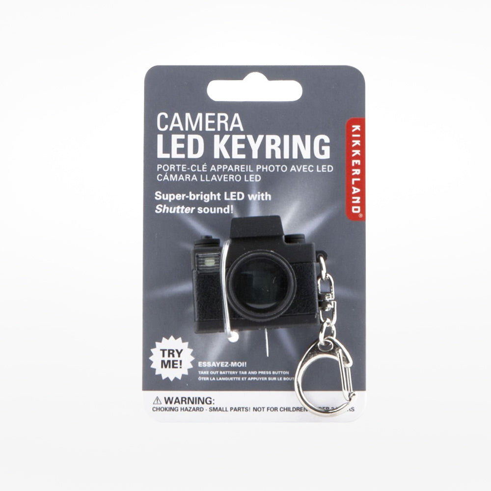 A keyring in the shape of a black camera with grey packaging.