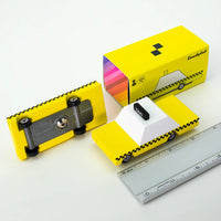 Yellow toy car with a ruler for scale on a white background 