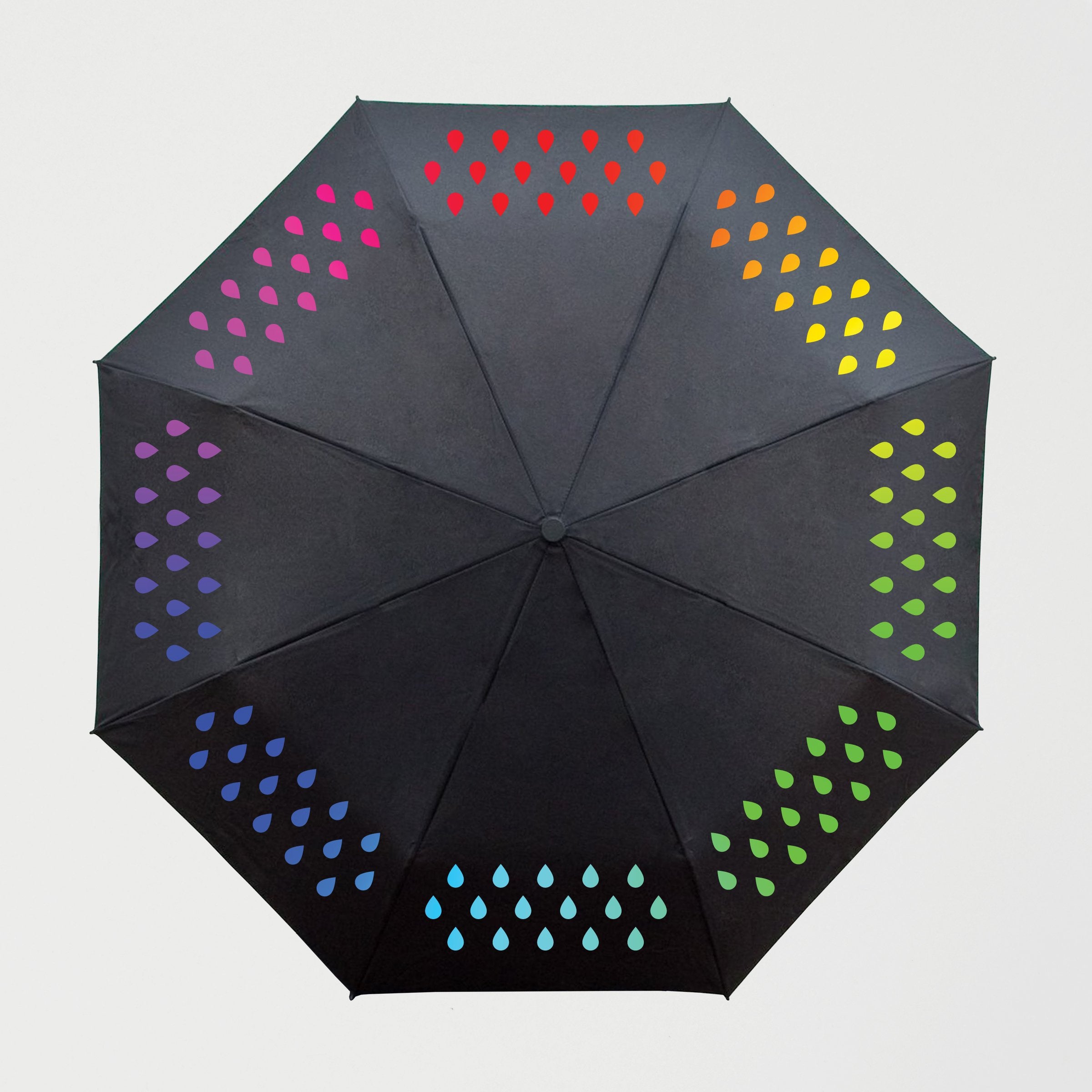 An open colour changing umbrella with a colourful raindrop pattern on a black background.