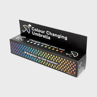 A packaging box for a colour changing umbrella with a pattern of colourful raindrops on a black background. 