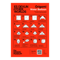 An origami water balloon instruction poster titled 'ES DEVLIN : OTHER WORLDS' and 'Origami Water Balloon' on a bright red background, with 16 numbered steps, the Design Museum logo, and a QR code.