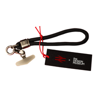Black keychain with red string and tag from The Design Museum on a white background