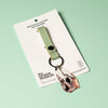 Recycled leather key fob with a tag on a white card against a light green background