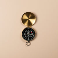 Gold compass on a beige background