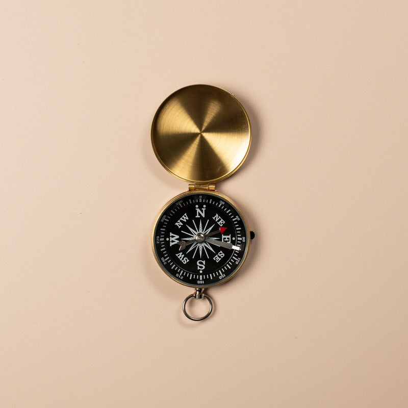Gold compass on a beige background