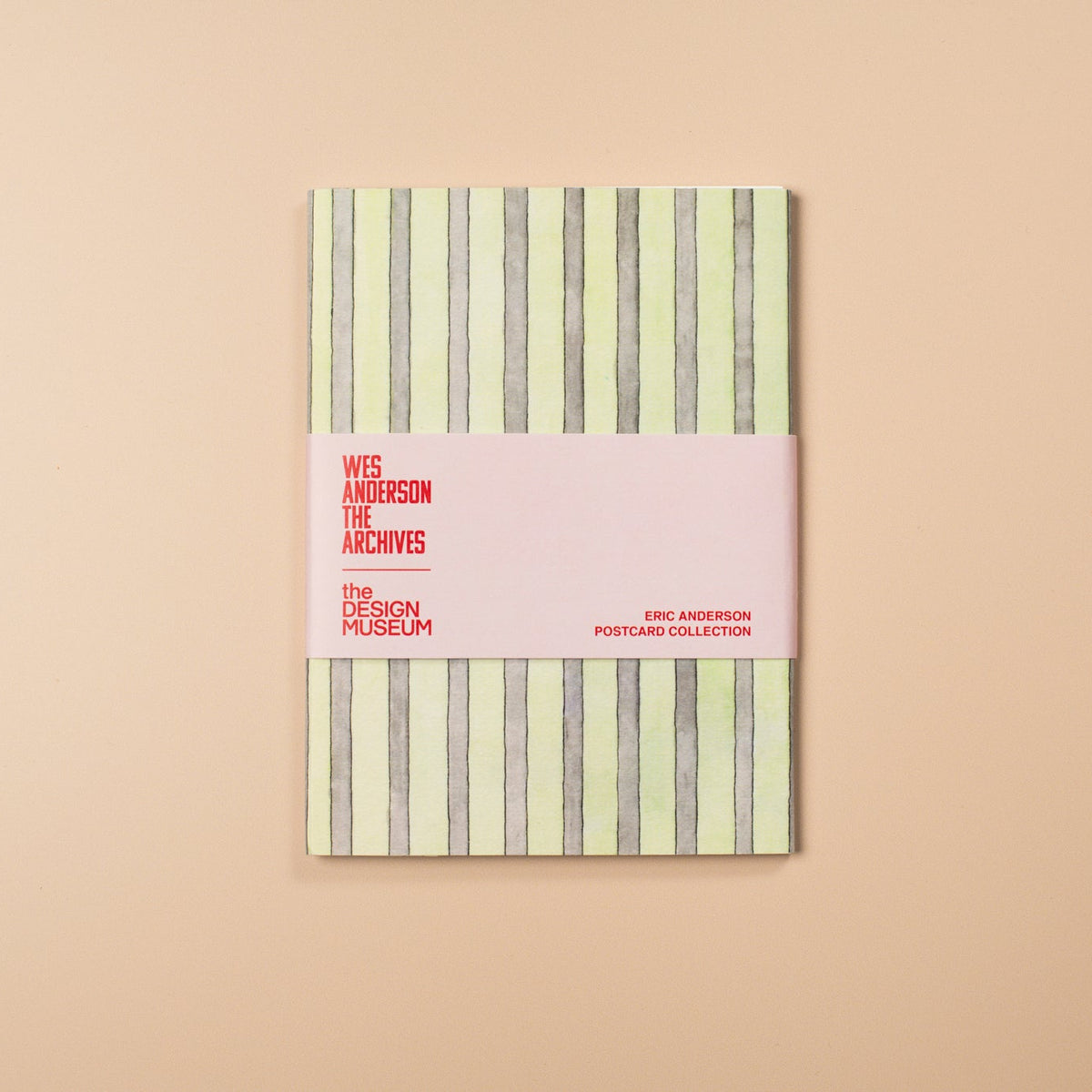 Notebook with striped cover and pink band on a beige background