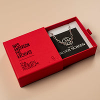 Red box with a necklace inside, featuring 'Wes Anderson The Archives' and 'The Design Museum' branding.