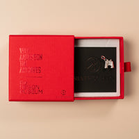 Red box with 'V&A Design Museum' branding, containing a silver object on a beige background