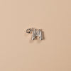 Silver binocular charm on a beige background