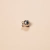 Small silver charm on a beige background
