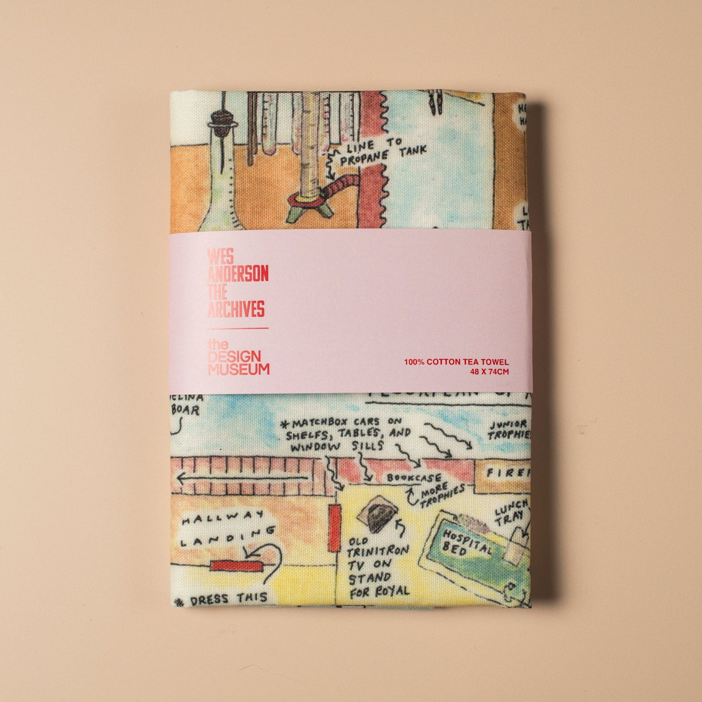 Decorative tea towel with vintage-style text and graphics on a beige background