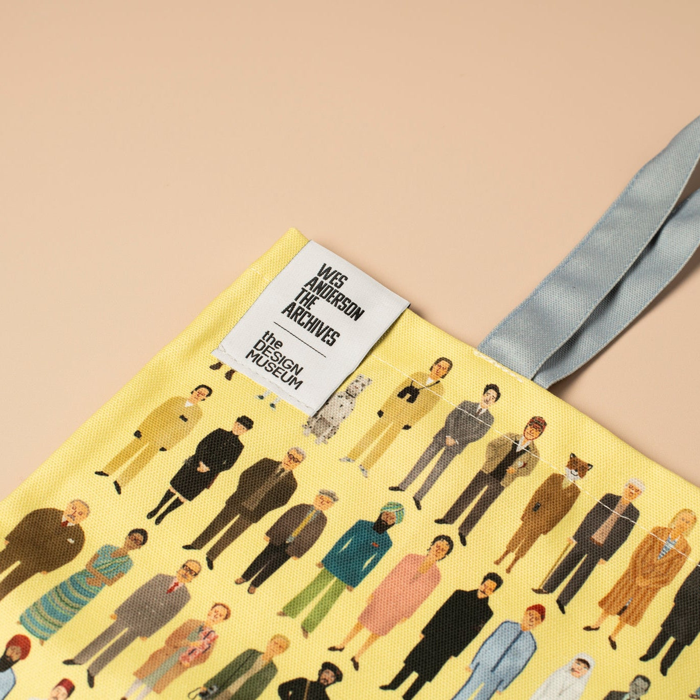 Tote bag with a pattern of people on a yellow background, featuring the Victoria & Albert Museum.