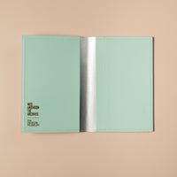 Open light blue passport holder with brand name on a beige background