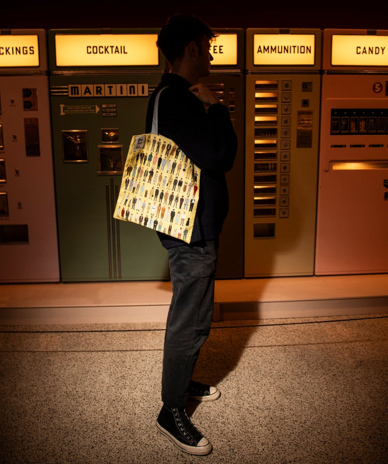 Person holding a yellow tote bag in a spotlight