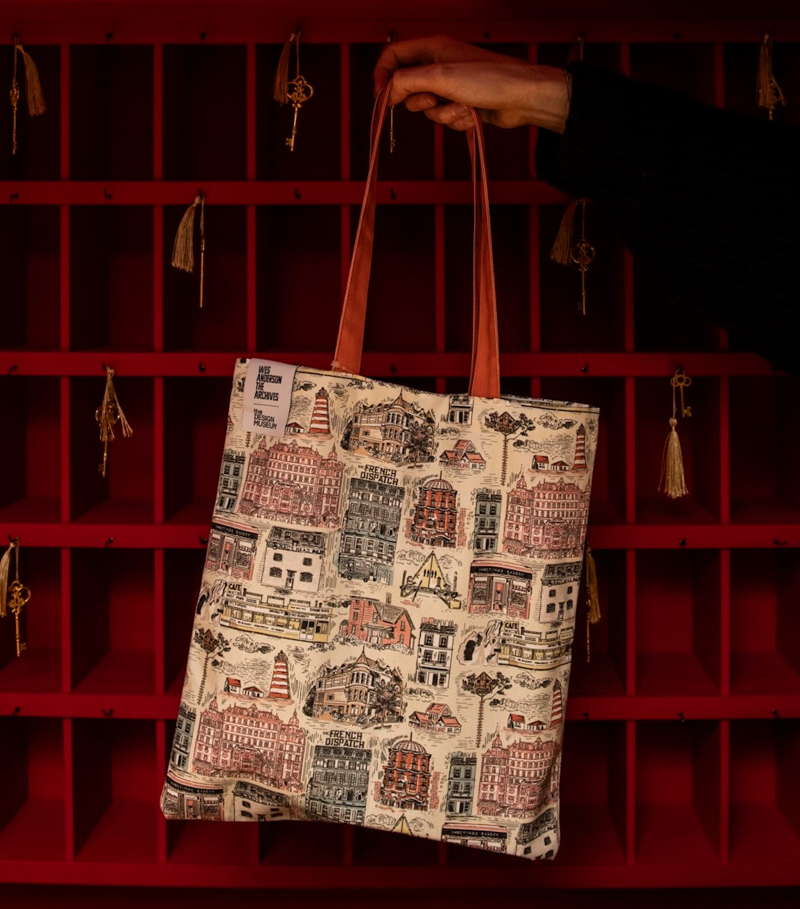 Hand holding a bag in front of a red backing wall
