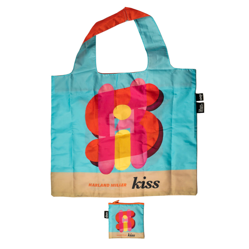 Colorful tote bag with floral design and 'kiss' branding on a beige background