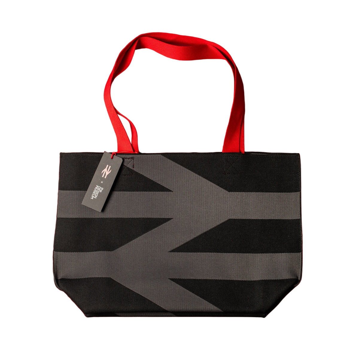 Black and gray striped tote bag with red handles on a white background