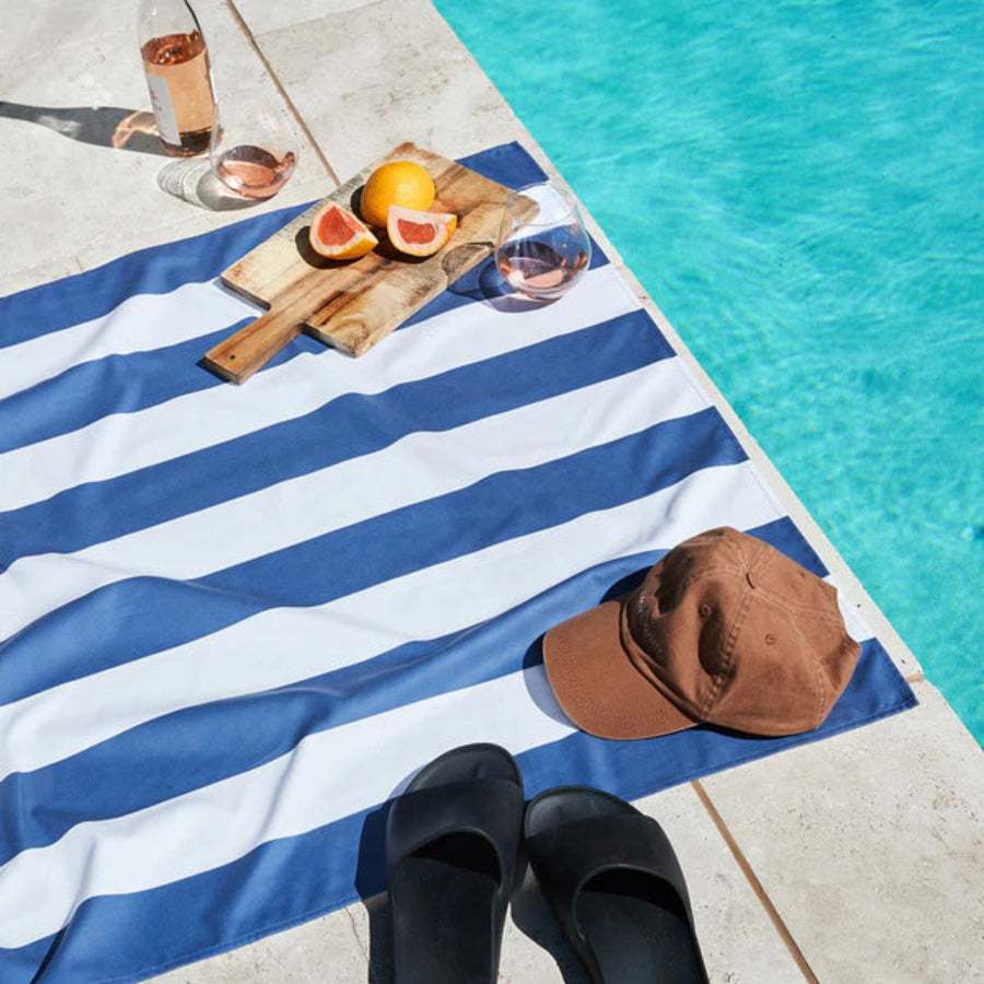 Dock & bay blue and white striped towel by a swimming pool on a sunny day 