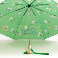 Open green umbrella on a white background with a duck shaped wooden handle