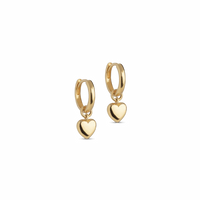 A pair of gold huggie hoop earrings with a small dangling heart charm, shown on a plain white background.