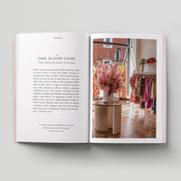 Open page of Eco London book featuring a photograph of One Scoop clothing store with lots of colourful clothes.