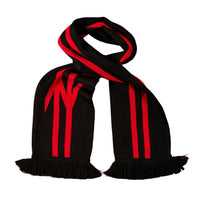 A black knit scarf with bold red stripes and a red stylized 'W' logo, laid flat on a solid red background.
