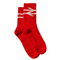 A pair of bright red crew socks with a white graphic design on the ribbed cuffs, displayed on a solid dark red background.