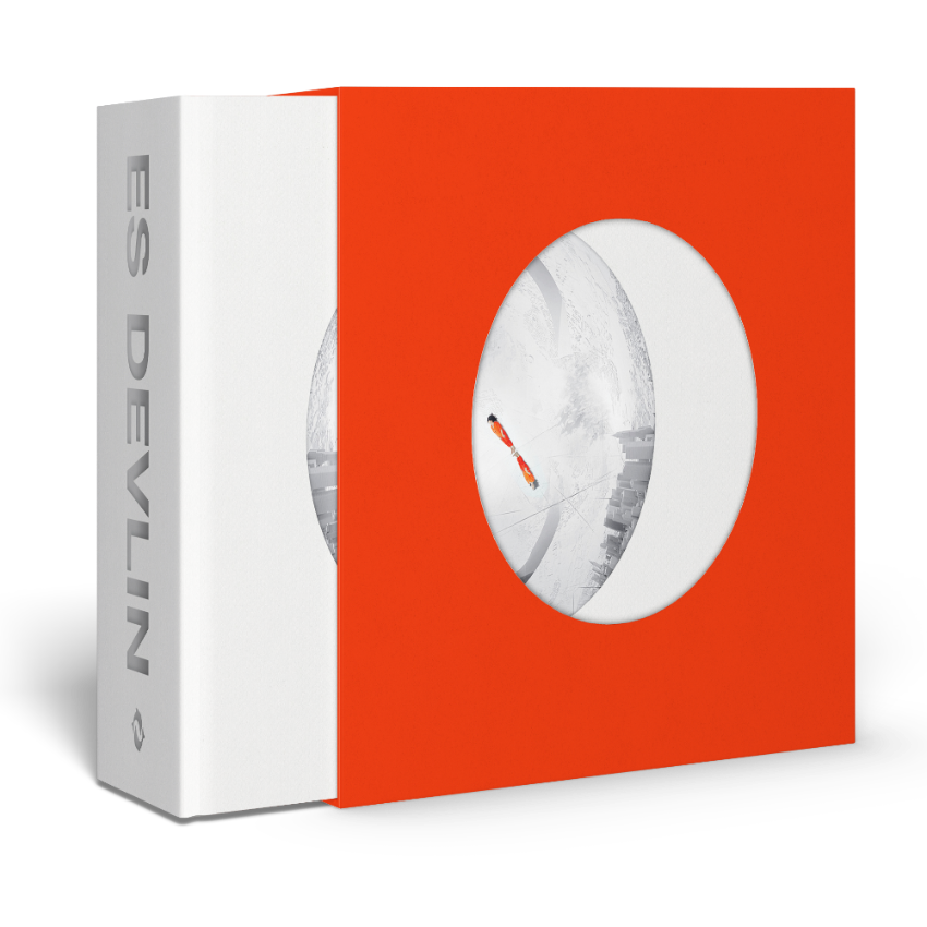 Red and white packaging box with a circular cutout displaying a white Es Devlin book