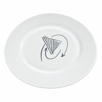 A white ceramic plate with a black hand-drawn graphic in the center, placed on a light wood desk with cardboard boxes in the background.