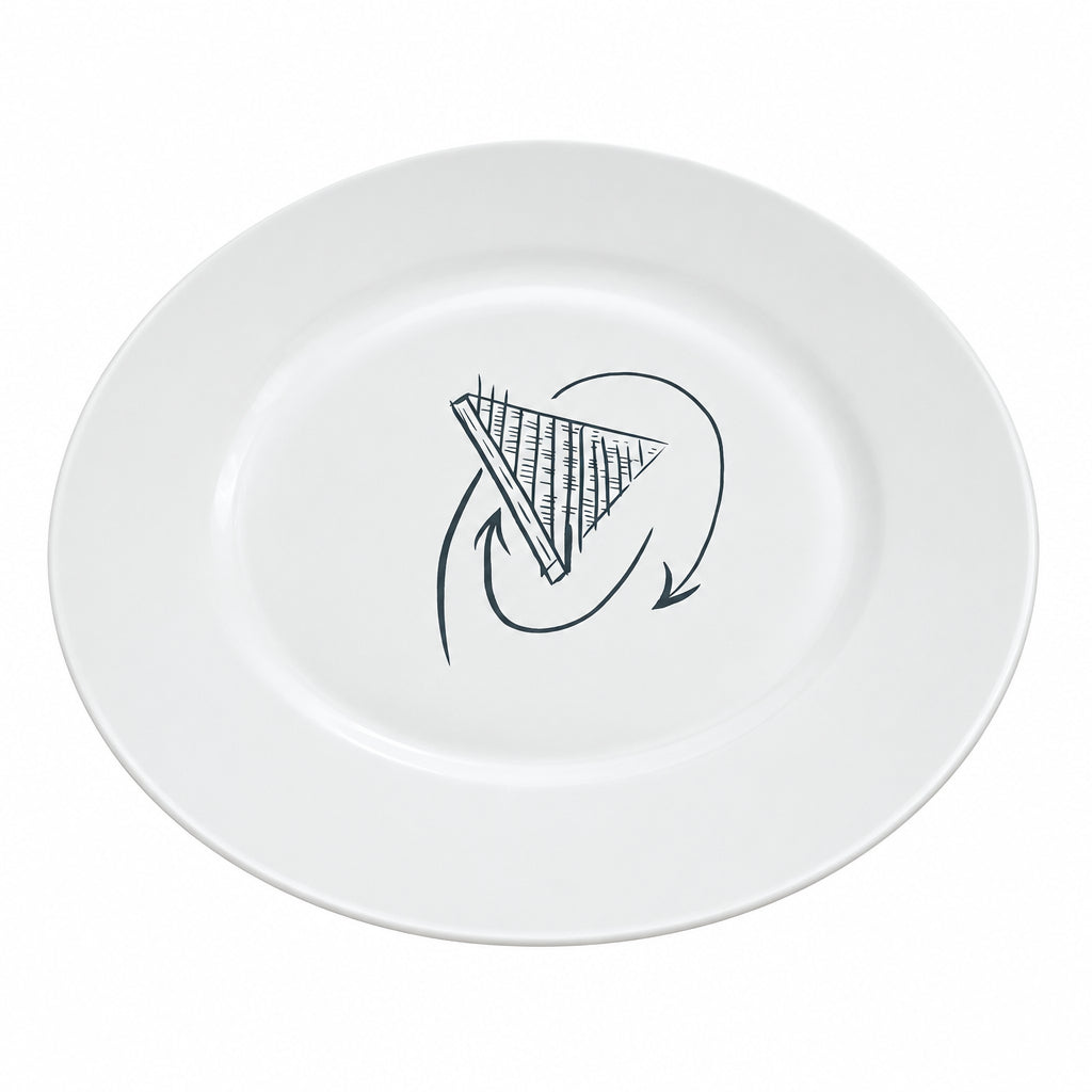 A white ceramic plate with a black hand-drawn graphic in the center, placed on a light wood desk with cardboard boxes in the background.