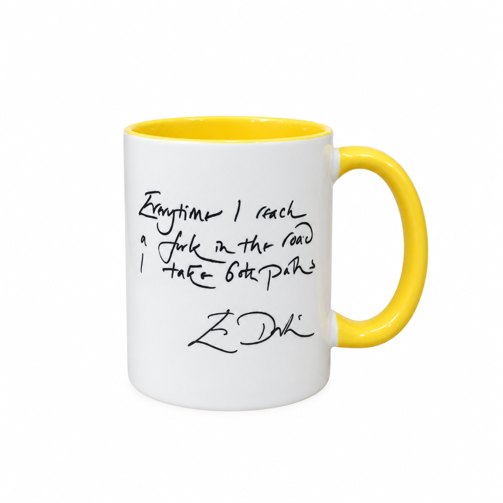 A white ceramic mug with a bright yellow interior and handle, featuring a black handwritten quote printed on the side.