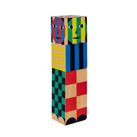 A multicolored wooden salt and pepper grinder with a geometric pattern and abstract faces.