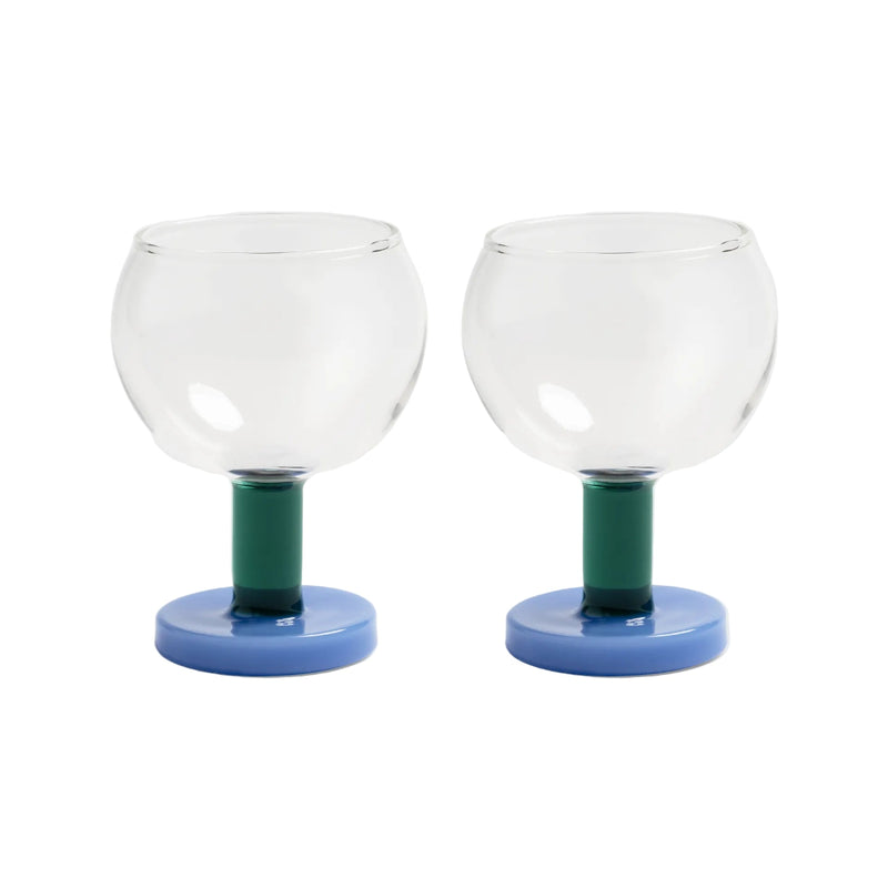 Two glass candle holders with green stems and blue bases on a white background